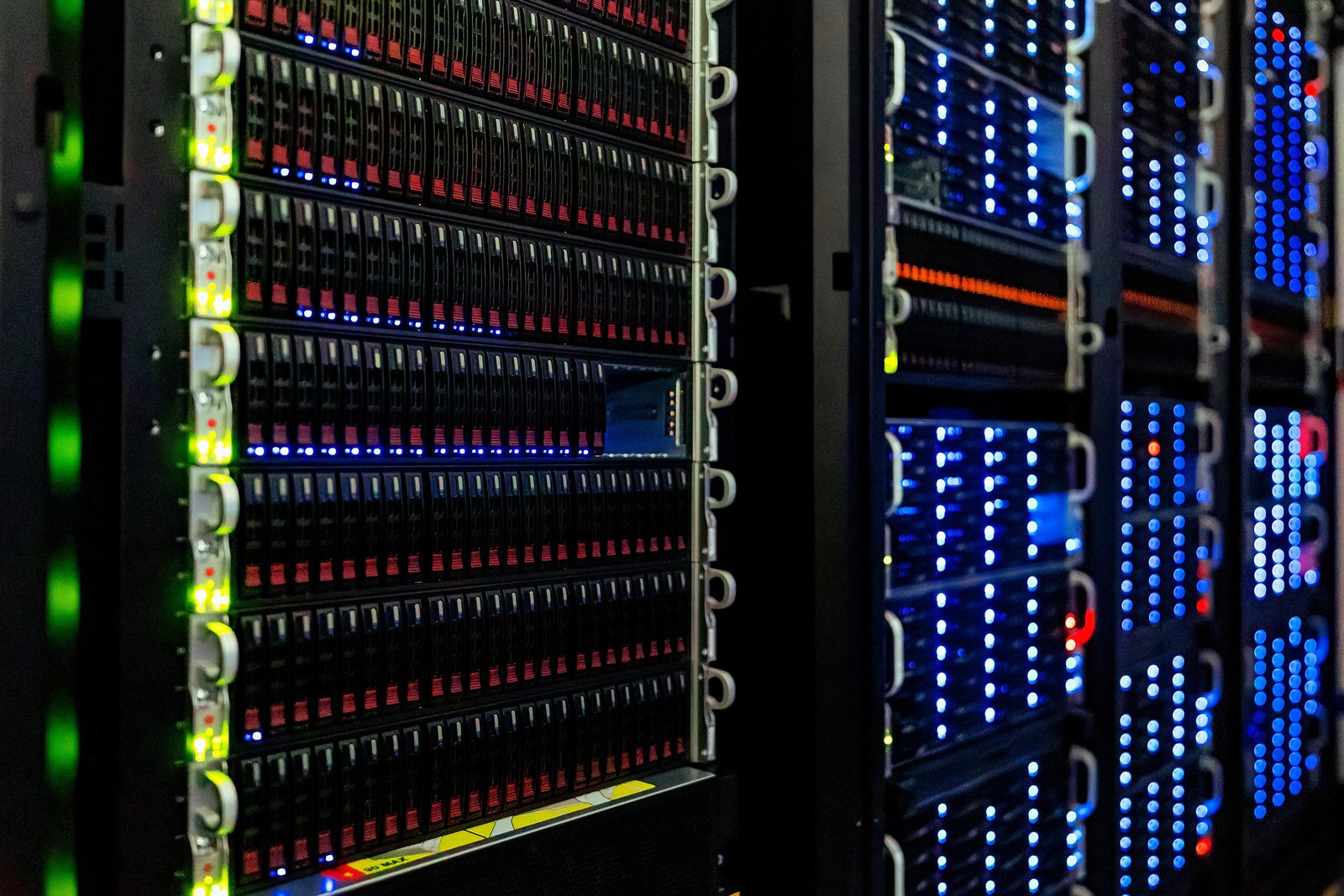 Rows of server racks lit by blue status lights in a computer room